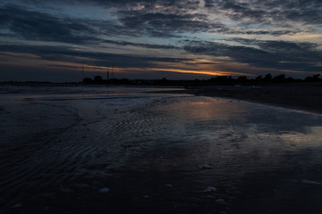 Sonnenuntergang hinter Wolken am Strand 