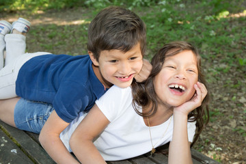 child boy lying in the grass with sister in the park