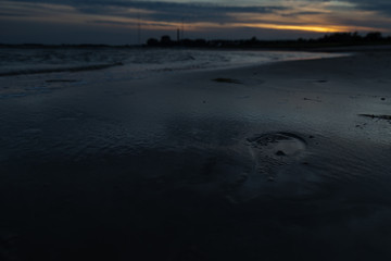 Fußspuren im nassen Sand vom Strand
