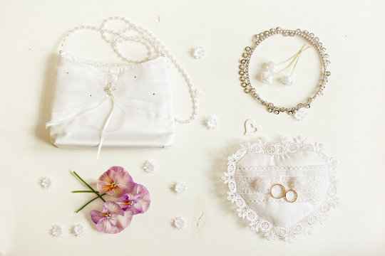Wedding background. Bride accessories: rings, handbag, boutonniere, necklace.