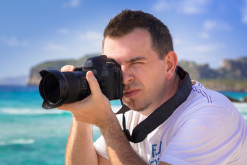Landscape photographer with camera on tropical beach