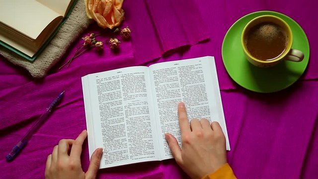 Reading the Bible on John 3:16 on purple old style background