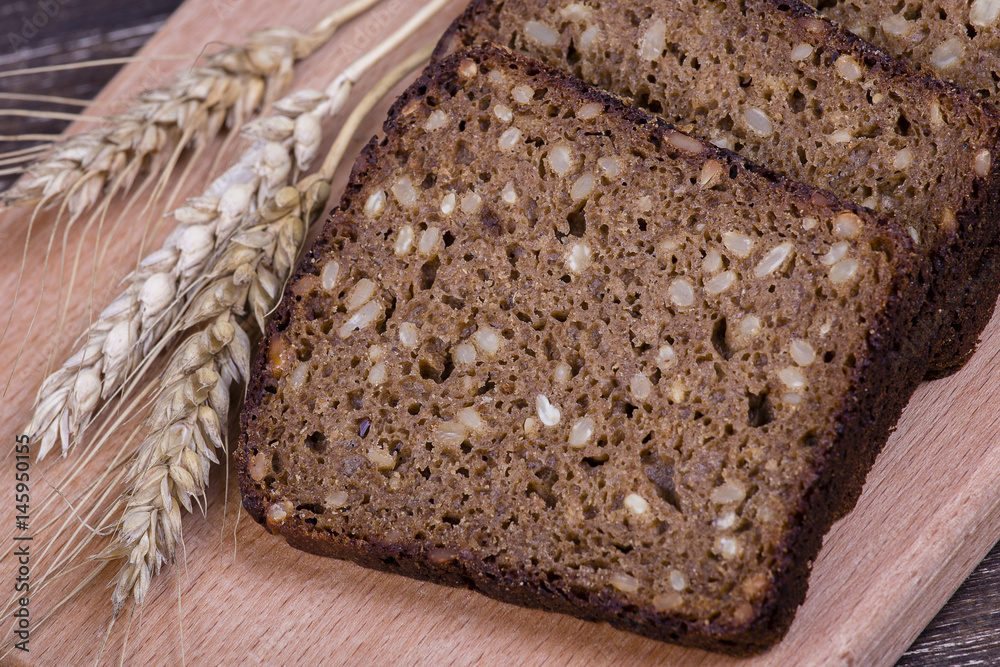 Wall mural fresh bread and wheat on the wooden, close up