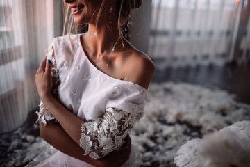 Fototapeta premium Young beautiful bride in boho style and white feathers.
