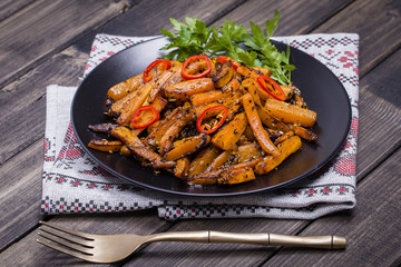 Roasted carrots in black plate, close up