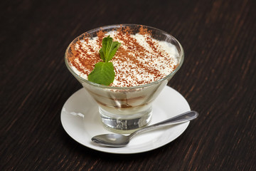 Tiramisu creme cake dessert in glass with mint leaves