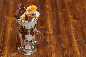 Ice cream chocolate cocktail in glass with syrup and banana