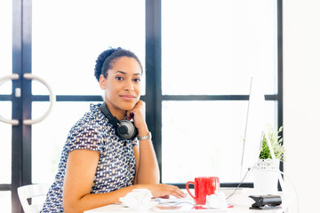 Portrait of smiling afro-american office worker sitting in offfice