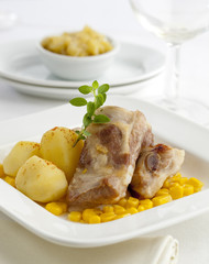 Gourmet pork ribs served with boiled potatoes and corn