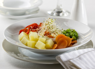 Vegetarian spring salad with green peas, carrot, potato, bell pepper and sprouts.