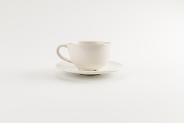 Close-up view of white coffee cup and saucer isolated on grey