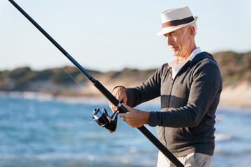 Senior man fishing at sea side