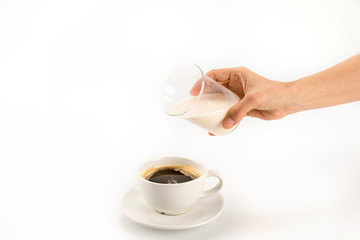 Cropped shot of person pouring milk into cup of fresh hot coffee