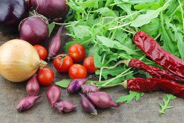  colorful display of onions,tomatoes,dried chili peppers and rucola on a grunge background