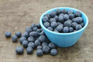 fresh blueberries in a blue bowl on a metal tray background