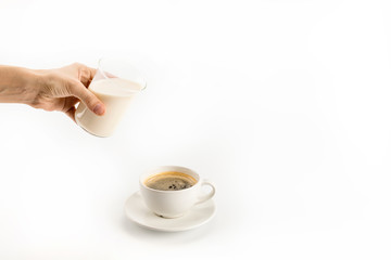 Close-up partial view of hand pouring milk into coffee isolated on white