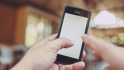 Hand holding smart phone with blank screen on white background