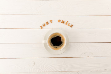 top view of coffee mug steam and Just smile lettering on wooden table