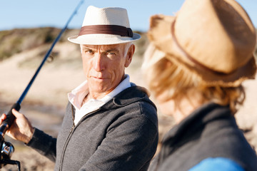 Obraz premium Senior man fishing with his grandson