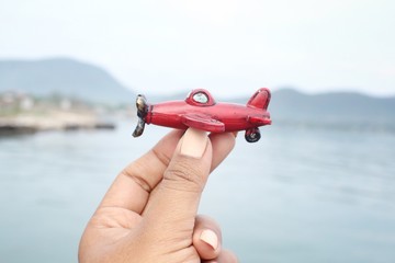 Toy plane on hand with sea