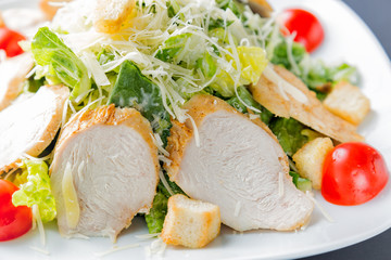 Healthy green organic caesar salad close up on white plate