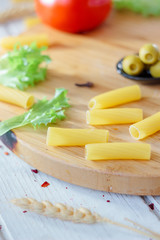 Italian tortiglioni pasta ready to cooking on kitchen board.