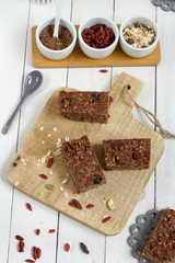 Energy bars with oat, Goji berries, sesame, chocolate and honey. White background, white pottery.