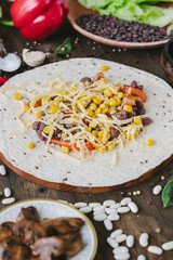 Vegetables, beans and cheese over tortilla bread - vegetarian mexican salad tacos.