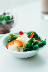 Healthy salad in a white ceramic bowl.