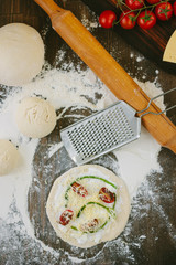 Cooking process of mini pizza with asparagus, tomatoes and cheese.