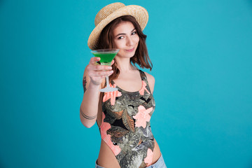 Happy young woman holding cocktail looking at camera