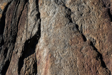 Red tinted eroded granite rock with cracks and gaps in surface structre
