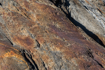 Red tinted eroded granite rock with cracks and gaps in surface structre
