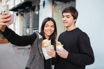 Young sister making selfie with her brother