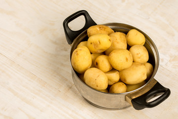 Pile of raw young potatoes in the metal pot
