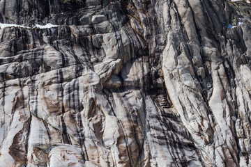 Eroded cracked granite cliff in multiple gray shades
