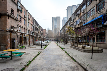 Une allée entre deux vieux immeubles de la ville de Xi'an et des buildings modernes en fond - obrazy, fototapety, plakaty