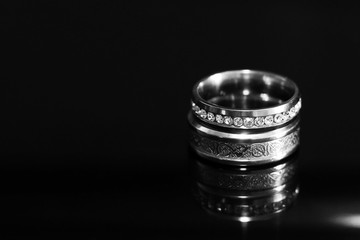 Wedding rings on a black glossy background