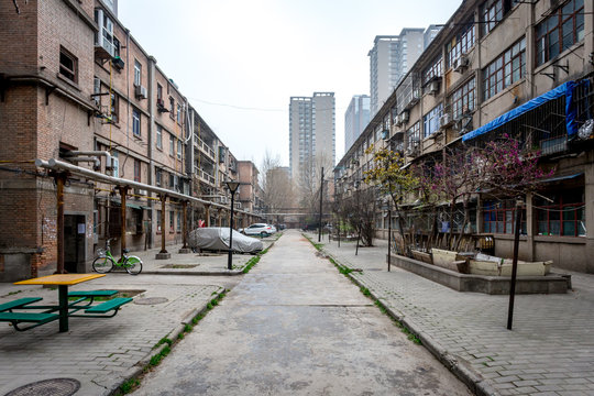 Une all&eacute;e entre deux vieux immeubles de la ville de Xi'an et des buildings modernes en fond