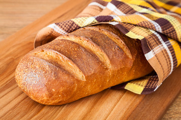 Traditional Russian wheat bread wrapped in a towel closeup