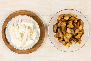 Flat lay fried young potatoes with white cheese