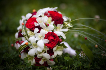 wedding bouquet of red roses lying on the grass