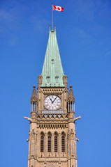 Fototapeta na wymiar Peace Tower (officially: the Tower of Victory and Peace) with blue sky background in downtown Ottawa, Ontario, Canada