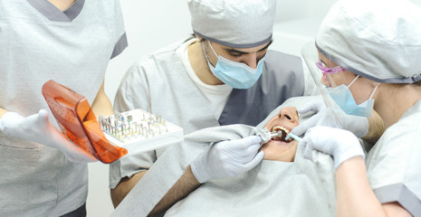 Dental surgery - Implant. Dentist surgeon with assistant
