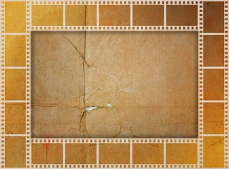 Vintage film strip frame on damaged paper in sepia tones.