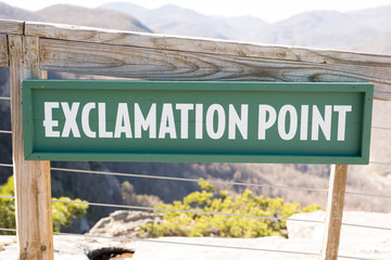 Green Hiking Sign Showing Exclamation Point with Wooden Railing
