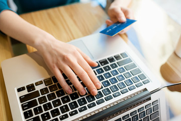 Hands typing on computer keyboard while making online payment from credit card