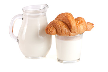 Jug and glass of milk with croissant isolated on white background