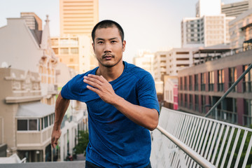 Fit young Asian man running through the city