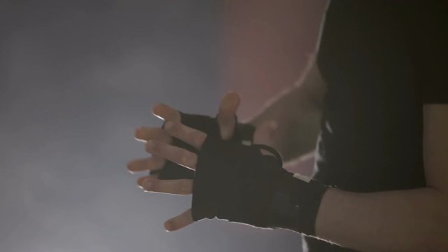 Mani di un uomo che si allacciano le fasce da boxe